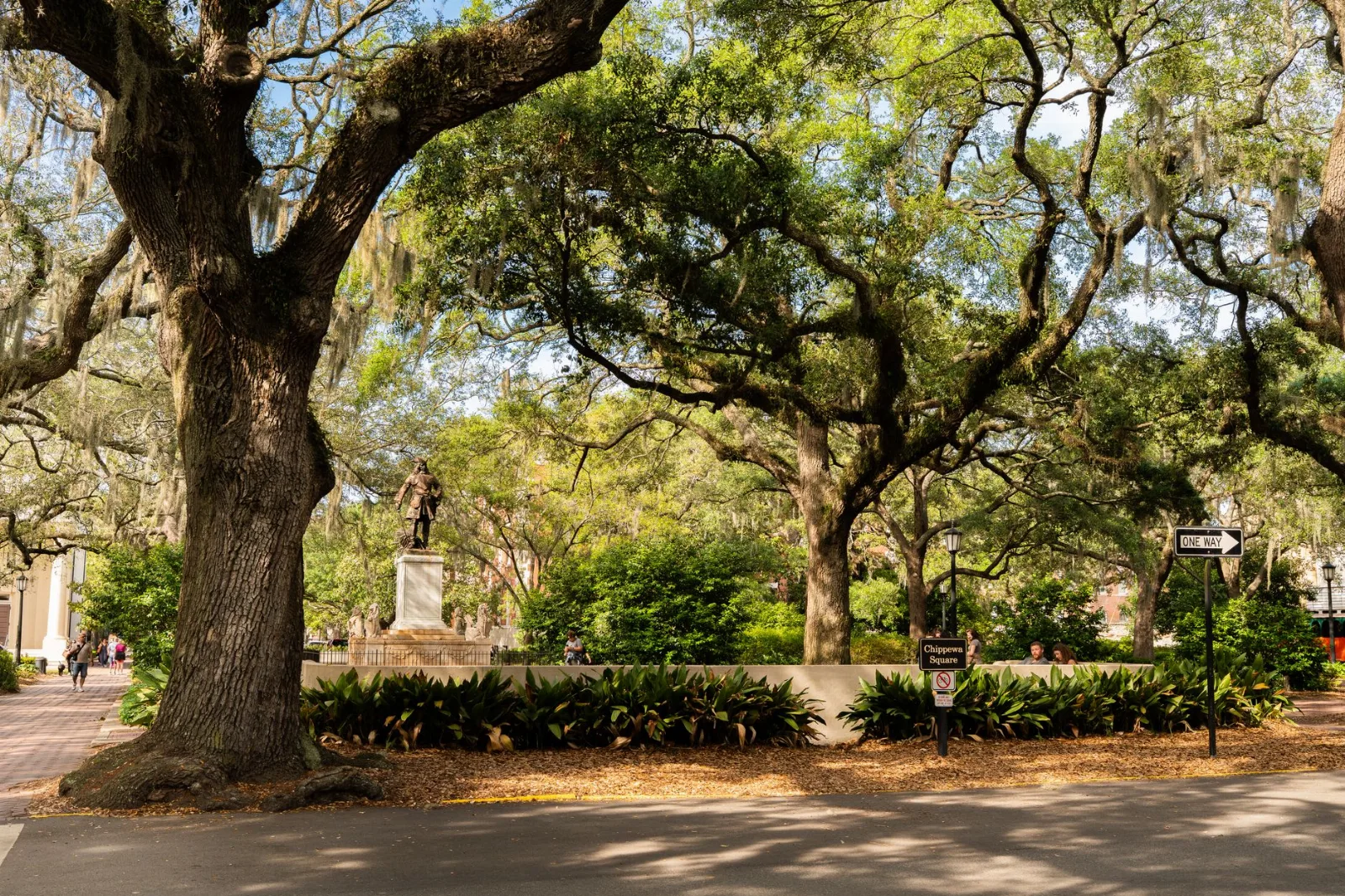 View of Chippewa Square in Savannah featuring lush live oaks and historical architecture.